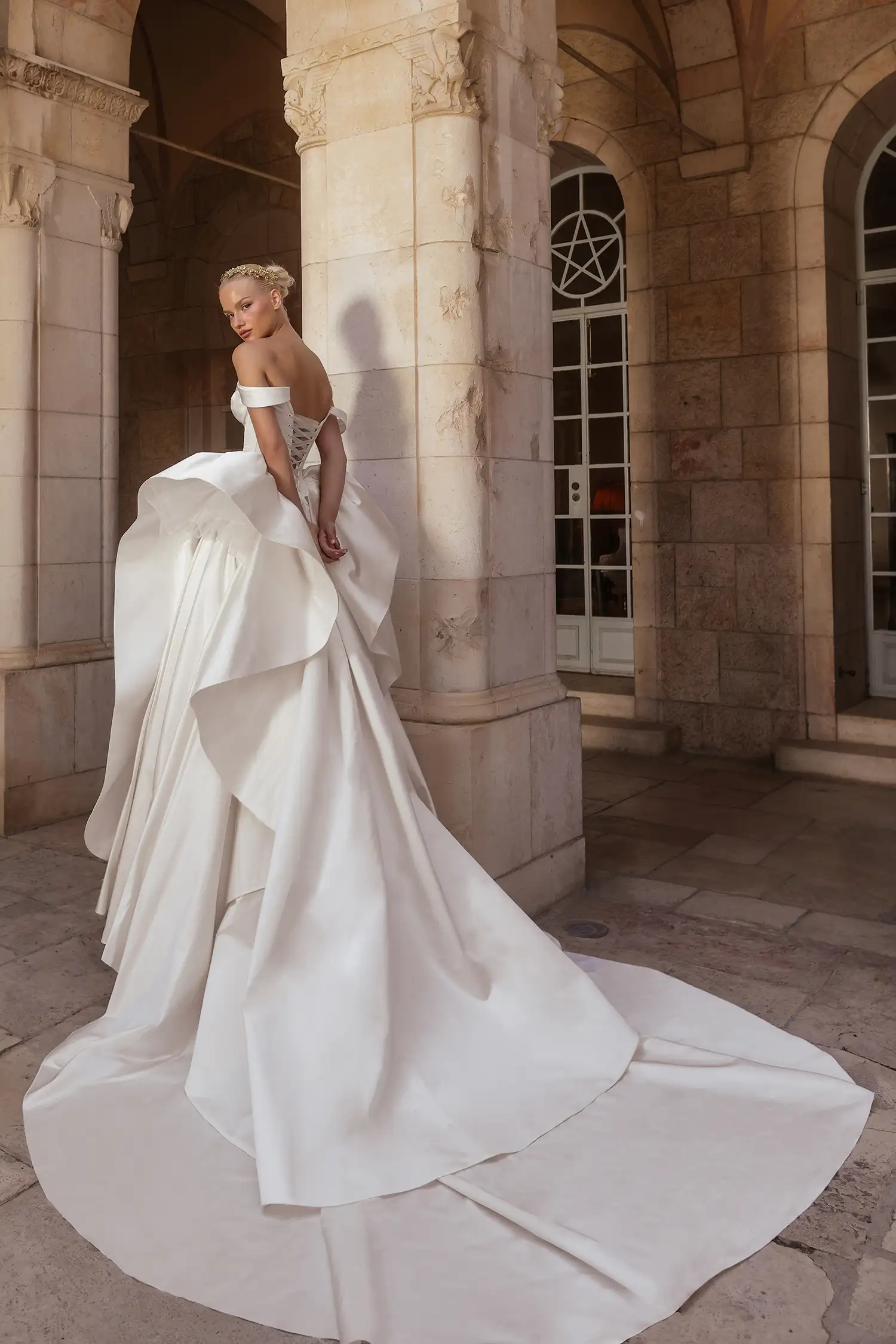 Matte satin ballgown with basque waist, draped sweetheart neckline and off-the-shoulder straps, and sculptural skirt ruffle detail.