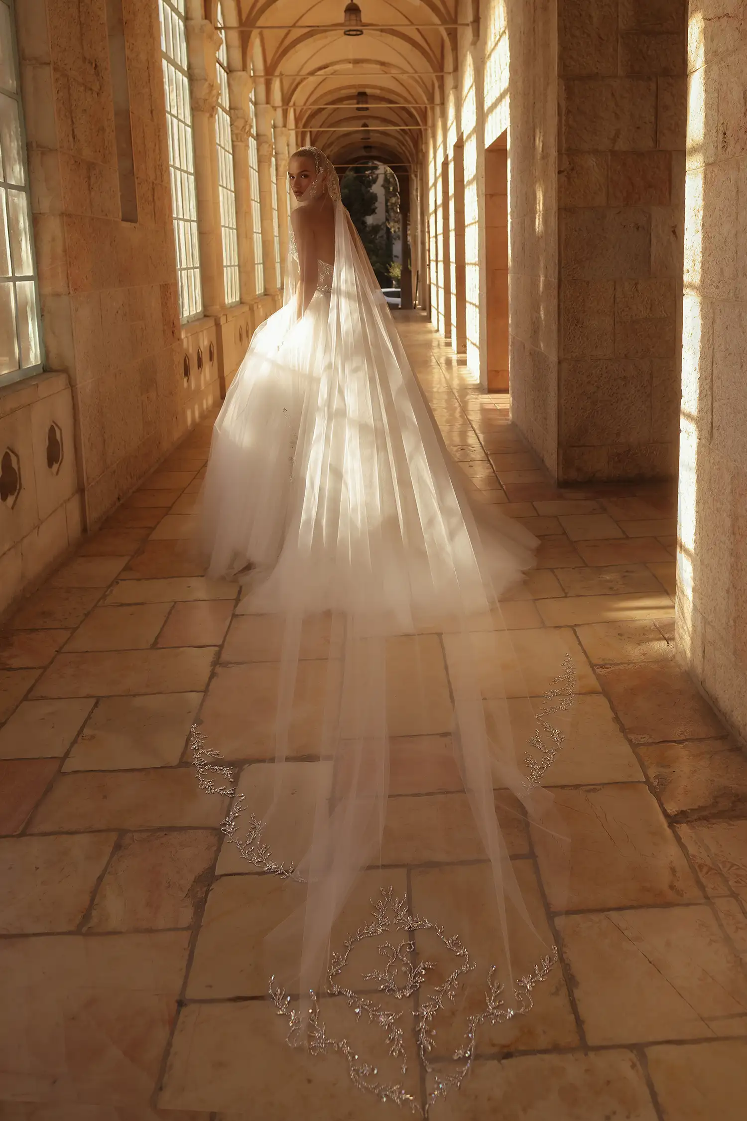 Strapless, sweetheart neckline ballgown with tulle plissé bodice fully embellished in mirror crystals and full tulle skirt with glitter underlay. Shown with sheer tulle gloves with mirror crystal appliqué.