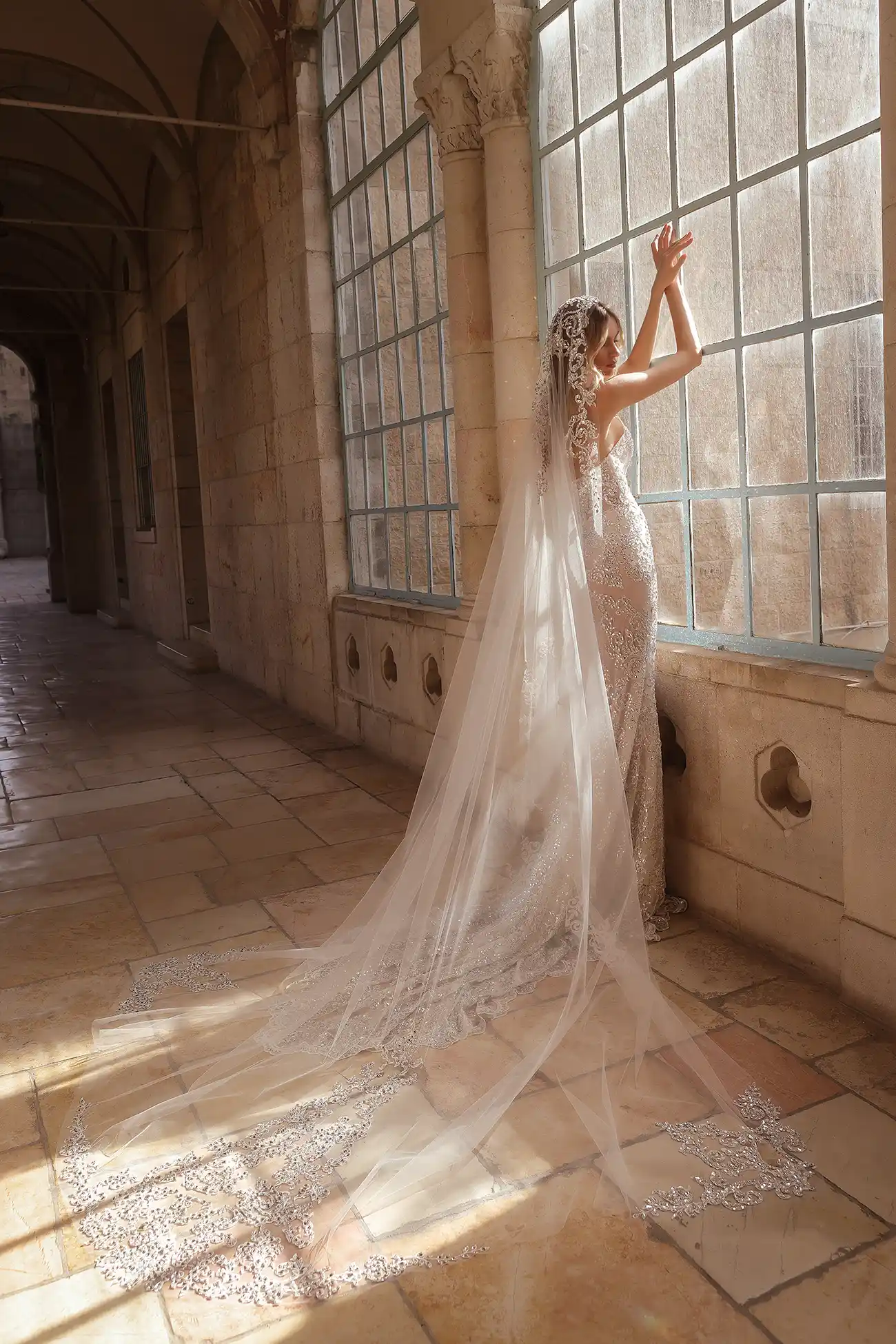 Strapless embroidered lace sheath gown fully hand beaded with mirror crystals, shown with cathedral-length embroidered lace and mirror crystal mantilla veil.