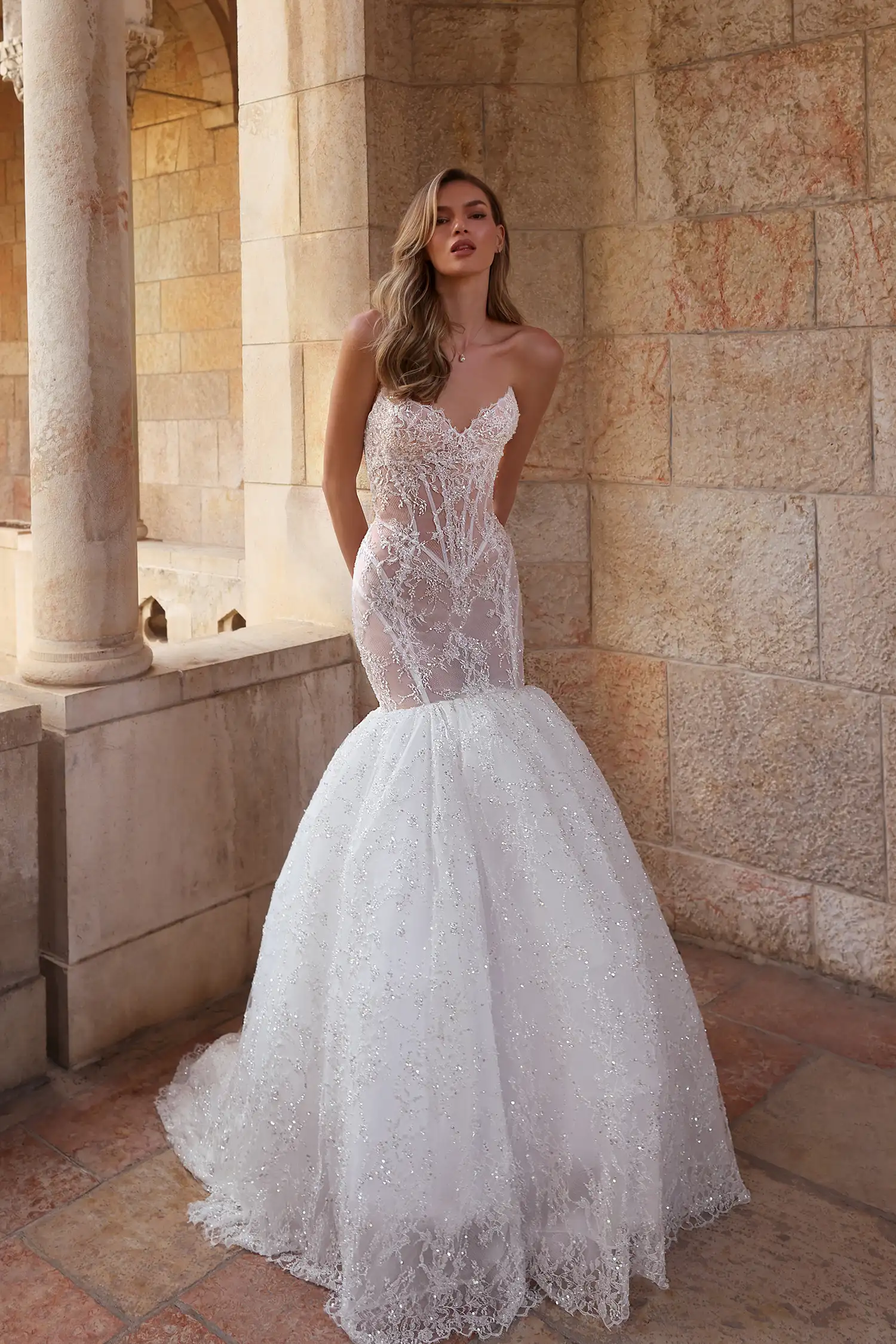Strapless sweetheart mermaid gown in hand-beaded chantilly lace with sheer cutout panels and water crystal embellishment. Shown with handmade organza flower stole.