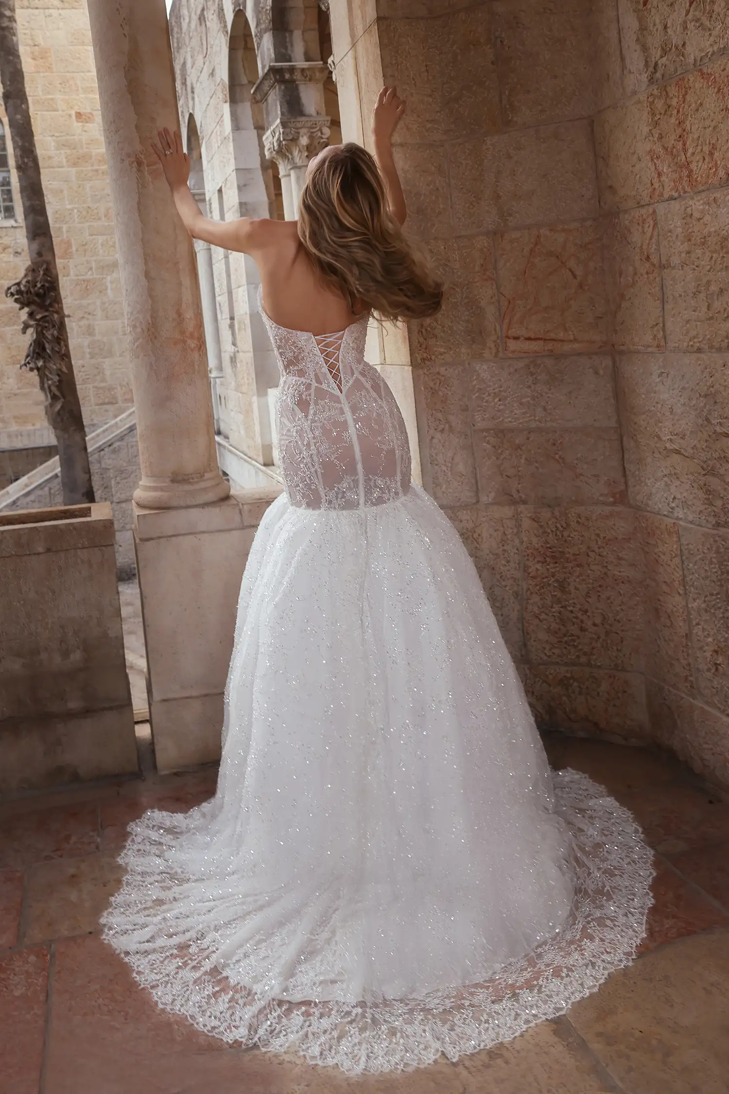 Strapless sweetheart mermaid gown in hand-beaded chantilly lace with sheer cutout panels and water crystal embellishment. Shown with handmade organza flower stole.
