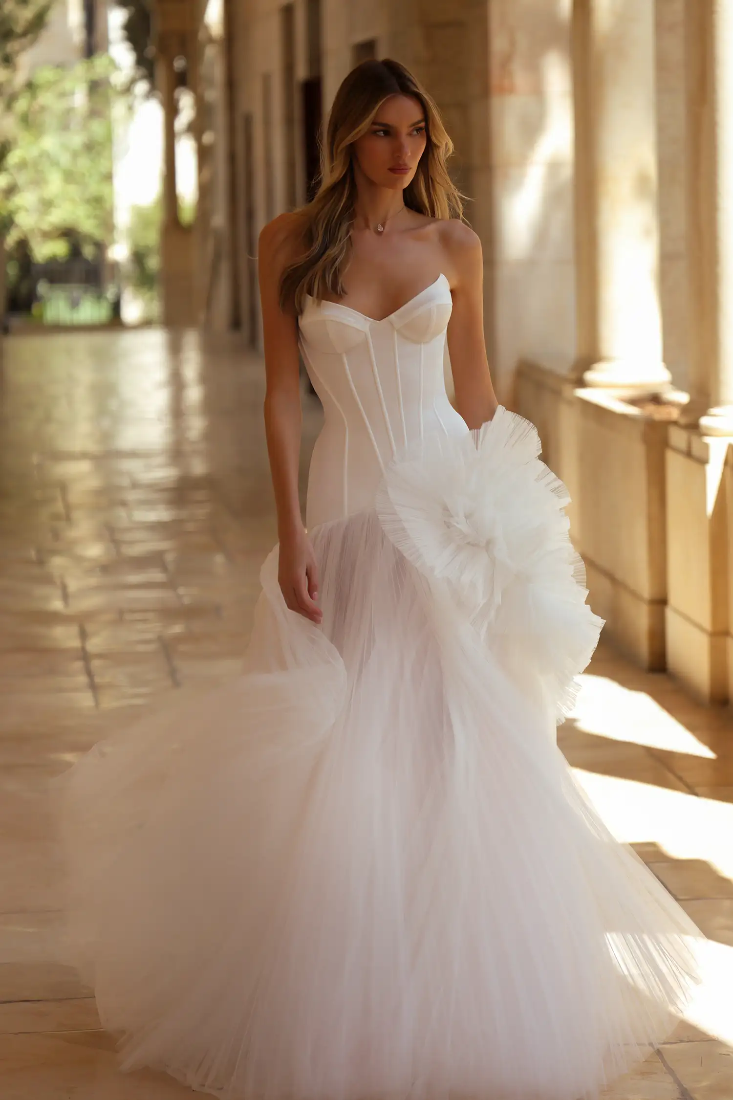 Drop-waist gown with strapless satin corset bodice, sunray pleated tulle skirt, and large dimensional tulle plissé flowers.