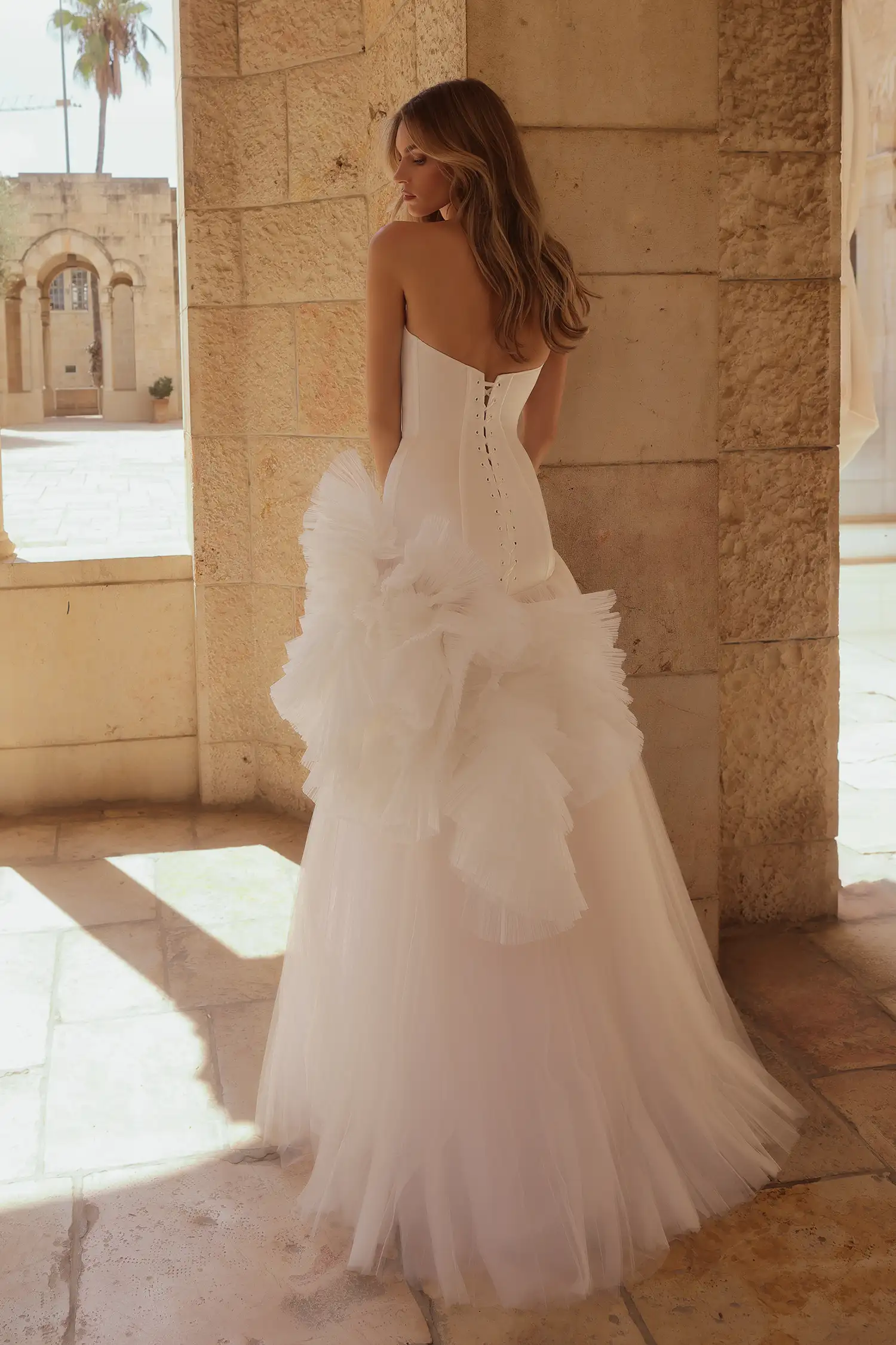 Drop-waist gown with strapless satin corset bodice, sunray pleated tulle skirt, and large dimensional tulle plissé flowers.