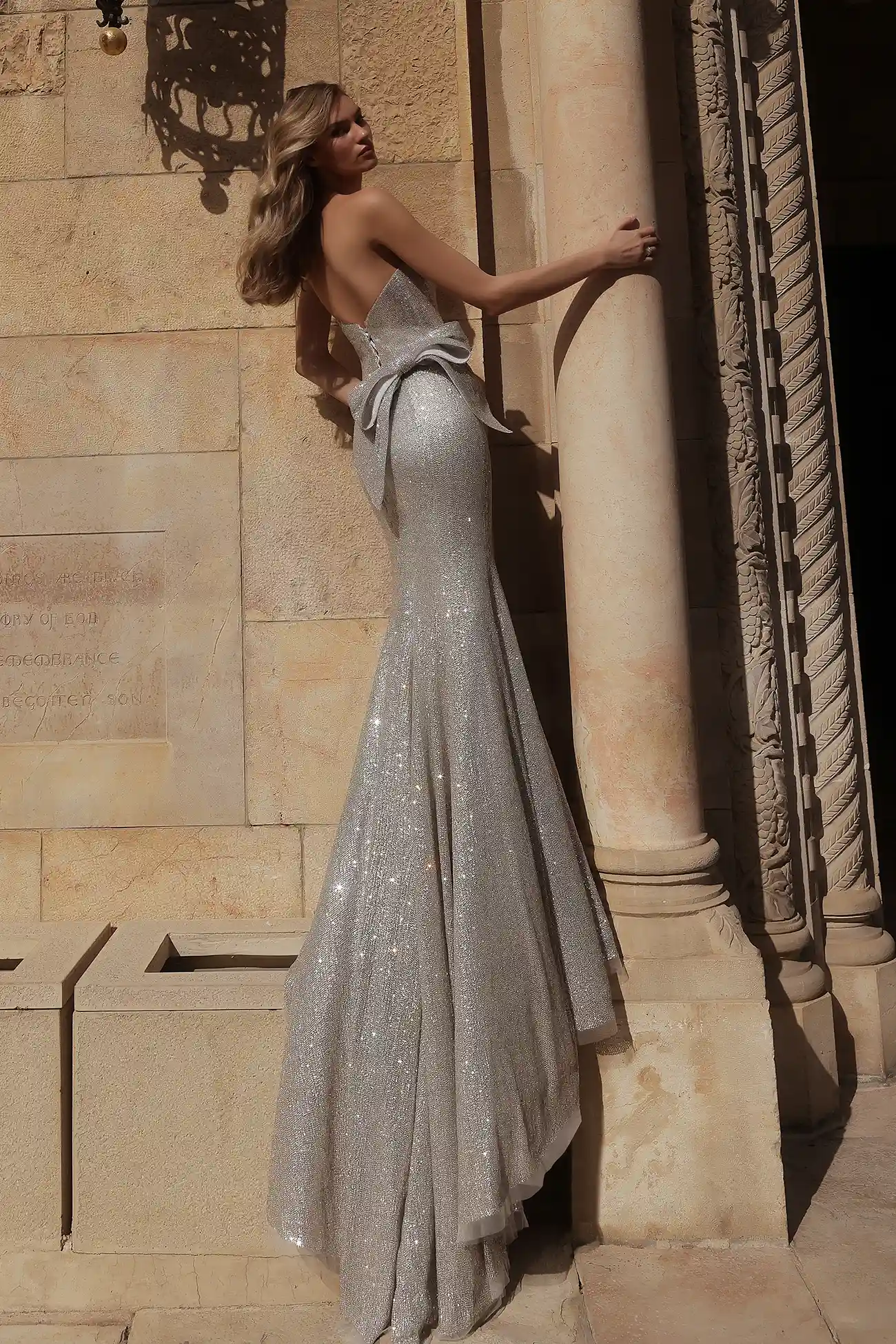 Strapless, straight-neckline fit-and-flare gown fully hand-beaded in silver crystals with silver crystal bow details.